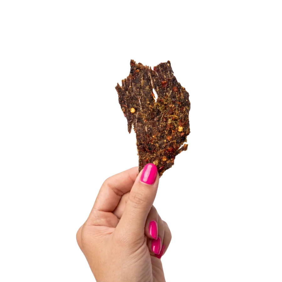 Hand holding GrazeOn beef jerky crisps